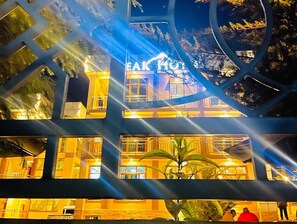 Un hotel de varios pisos con señalización iluminada y balcones.