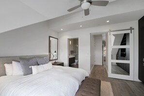 A modern bedroom with a large bed, a ceiling fan, and a sliding door leading to a bathroom. - 3 Bd, 3 Ba Mountain Village, Telluride Condo, Ski in ski out on Sunset Plaza (Telluride)