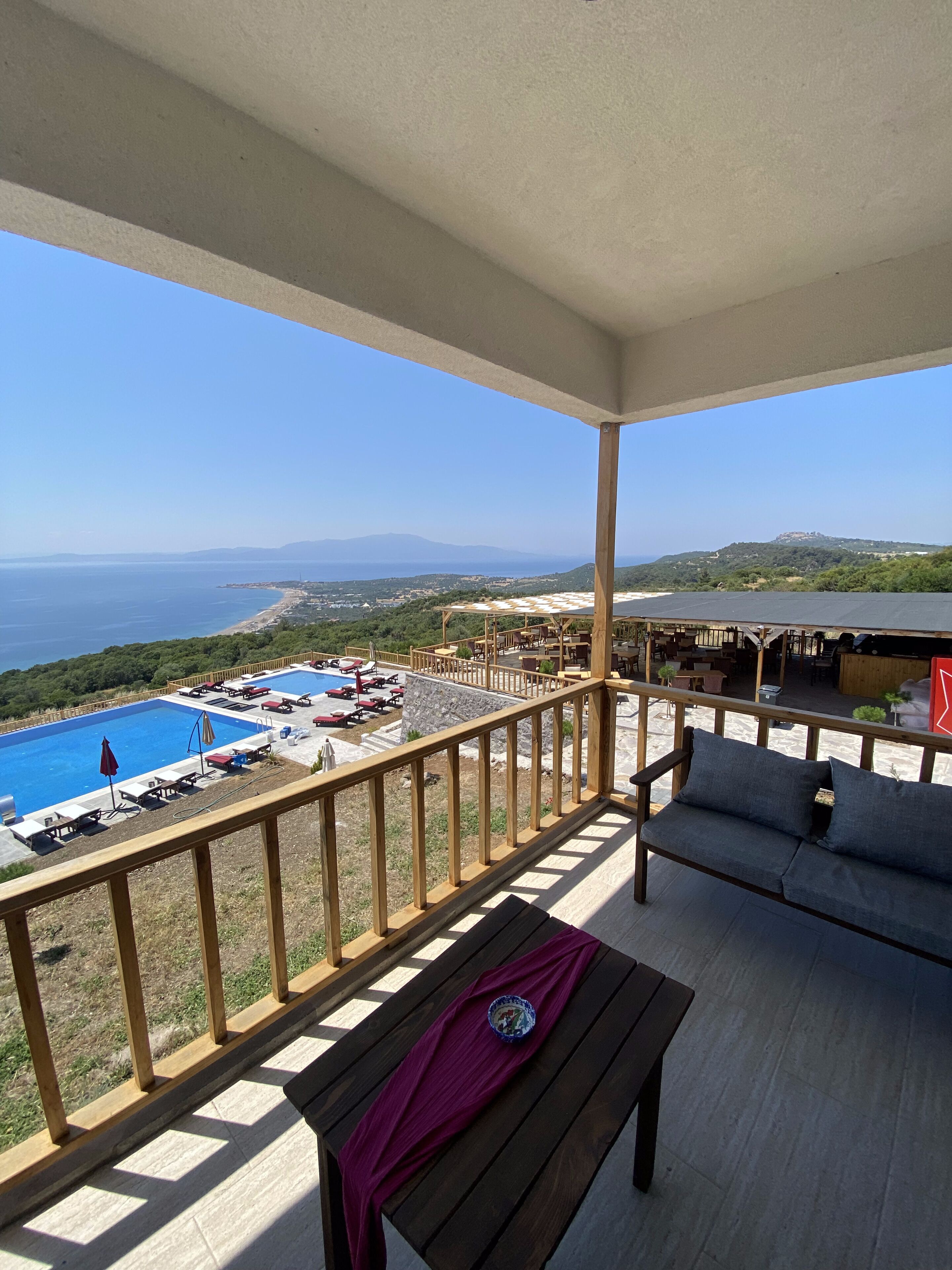 A balcony with a view of a swimming pool and a beach.