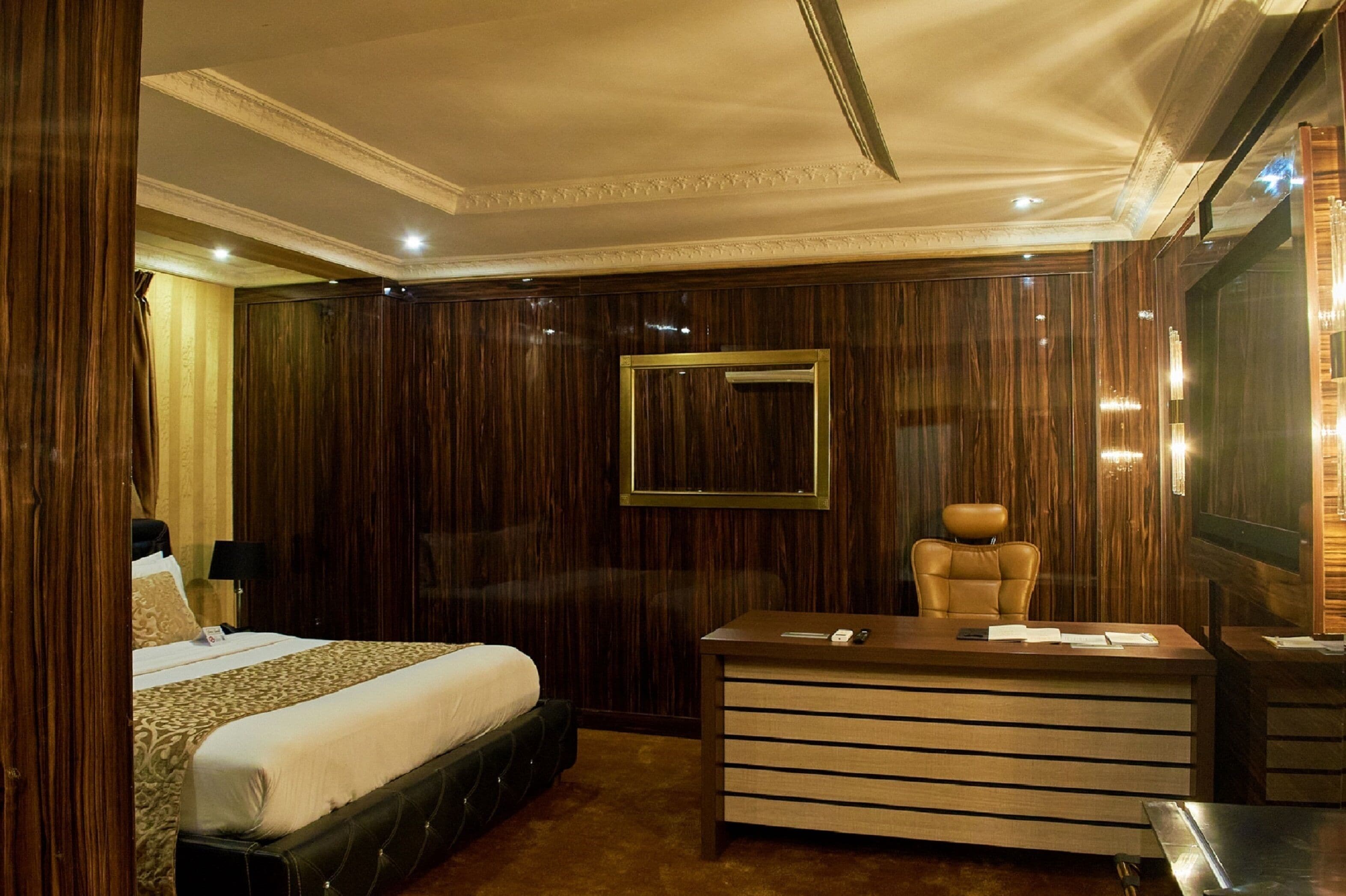 Une chambre d’hôtel avec un grand lit, un bureau avec des tiroirs, une chaise et un téléviseur.