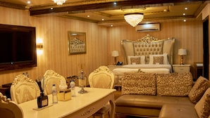 A luxurious bedroom with a large bed, a sitting area, and a dining table. - No.1 Hotel Ibadan (Ibadan)