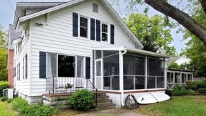 A white two-story house with a covered porch and a large windowed front area. - Minutes from Downtown St. Michaels and Tilghman | Private Dock | Outdoor Dining (Sherwood)