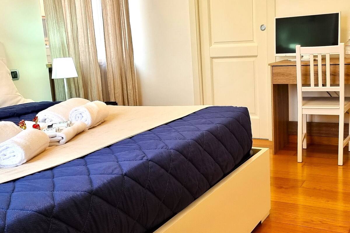 Een hotelkamer met een bed, een bureau, een stoel en een televisie.