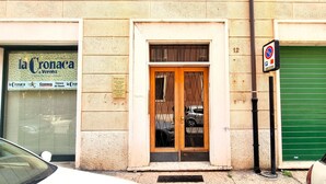 Een gebouw met een winkel genaamd "la Cronaca di Verona" en een gesloten, groene luik.