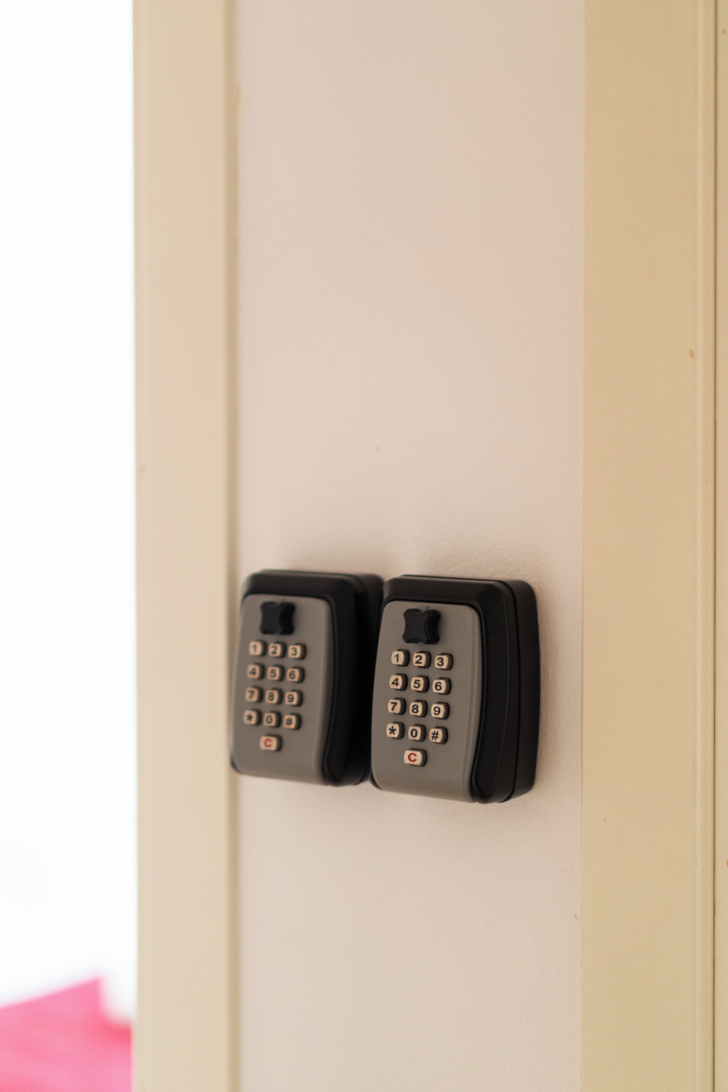 Zwei schwarze, an der Wand befestigte Telefone an einer beigen Tür.