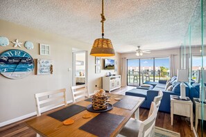 Relax in this spacious living area with a high ceiling, ceiling fan, and comfortable sofa set.