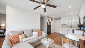 A modern living room with a sofa, coffee table, and a ceiling fan.