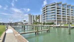 A waterfront hotel with multiple balconies, a marina, and a grassy area. - Spacious studio condo with the best amenities in Port Aransas!  Community pool, (Port Aransas)