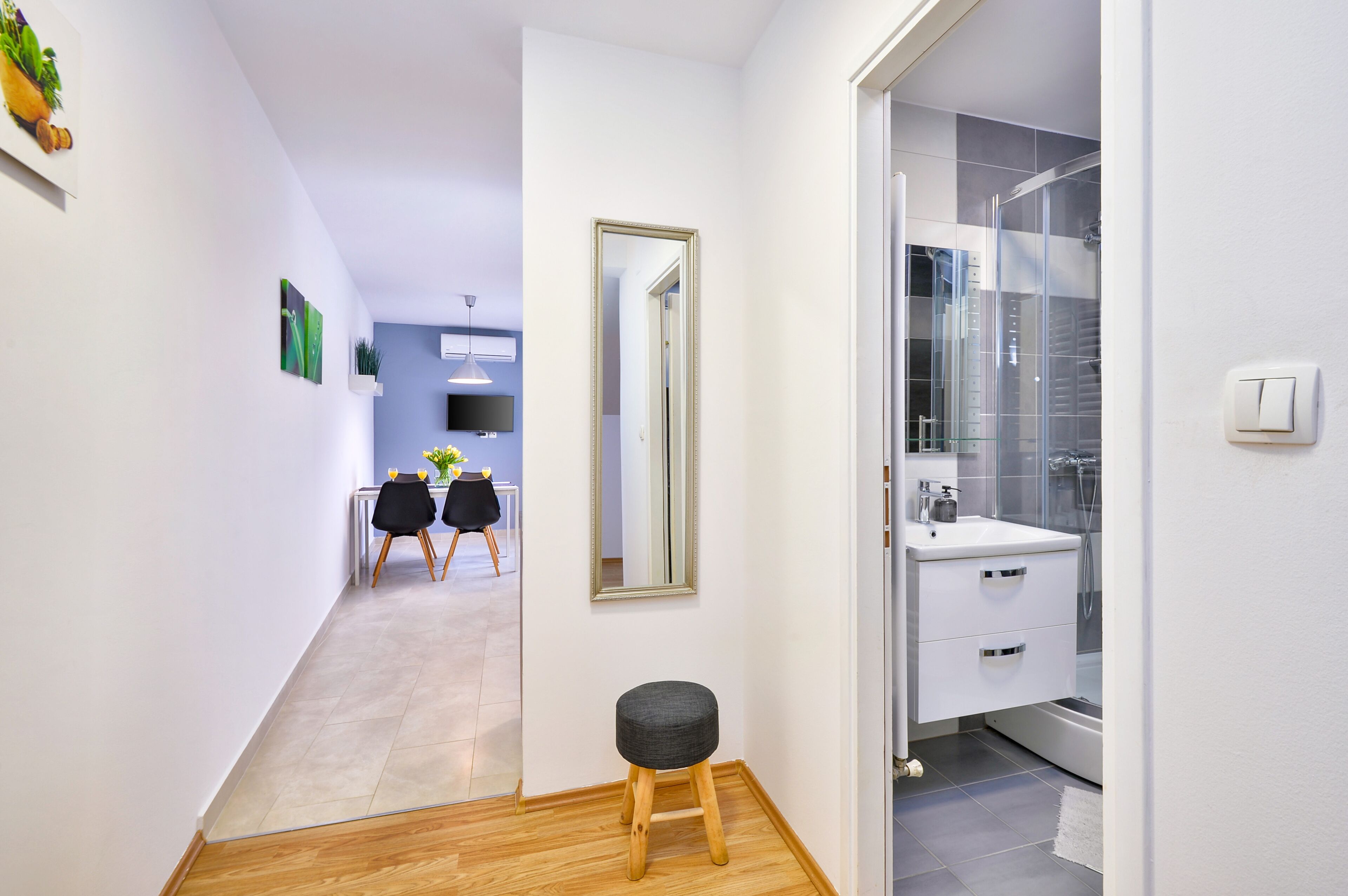 Un baño moderno con cabina de ducha de vidrio, un lavabo blanco y un espejo.