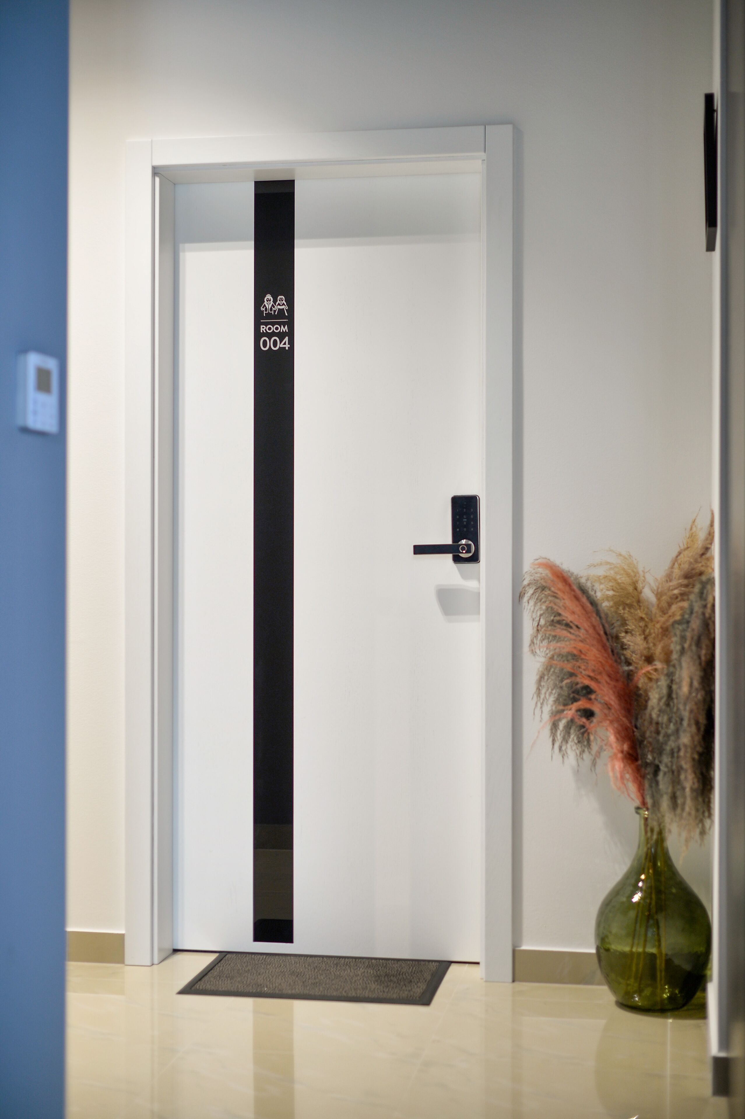 Puerta de una habitación de hotel con un letrero que dice "ROOM 004".