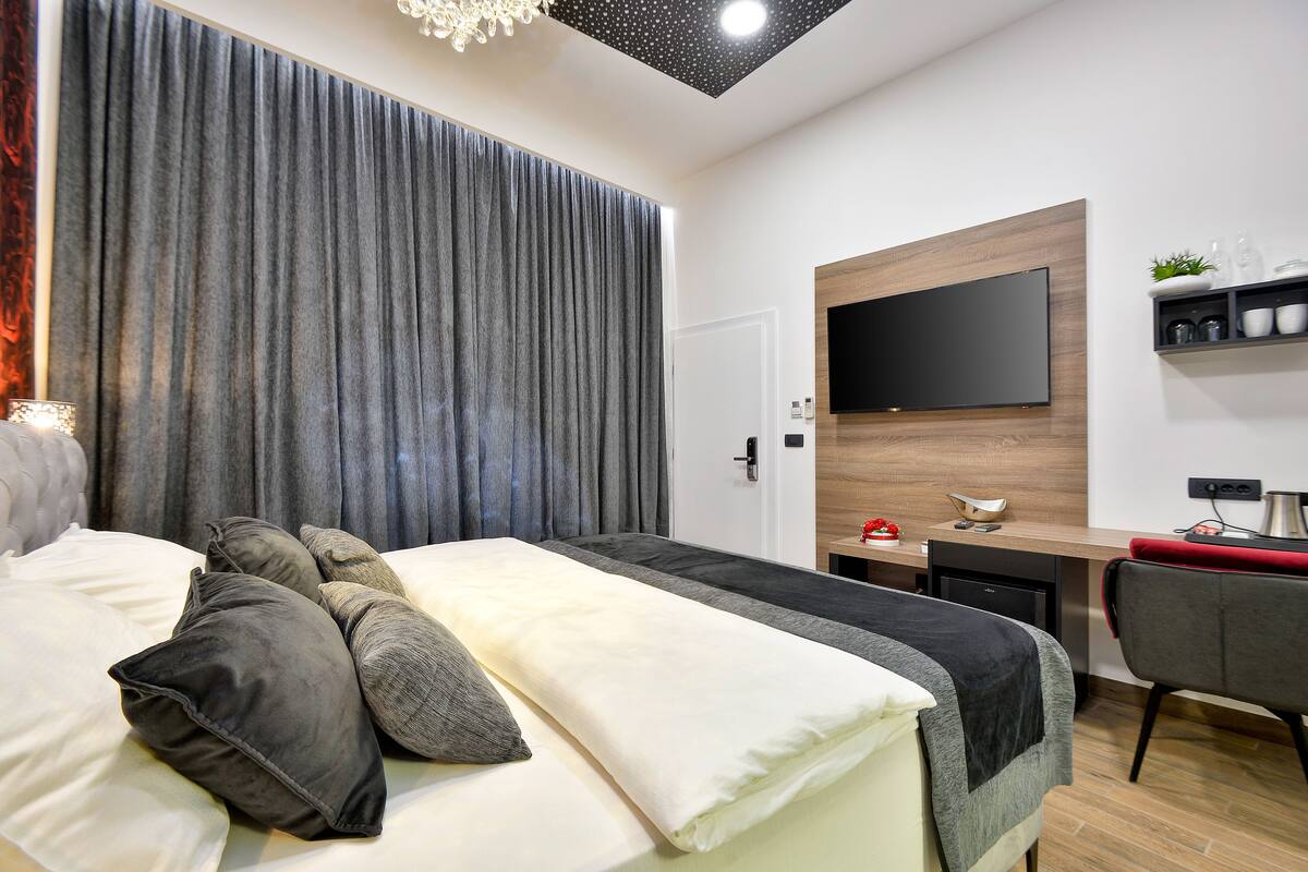 Deluxe Room 001 | Safe på rommet, skrivebord for bærbar PC og blendingsgardiner