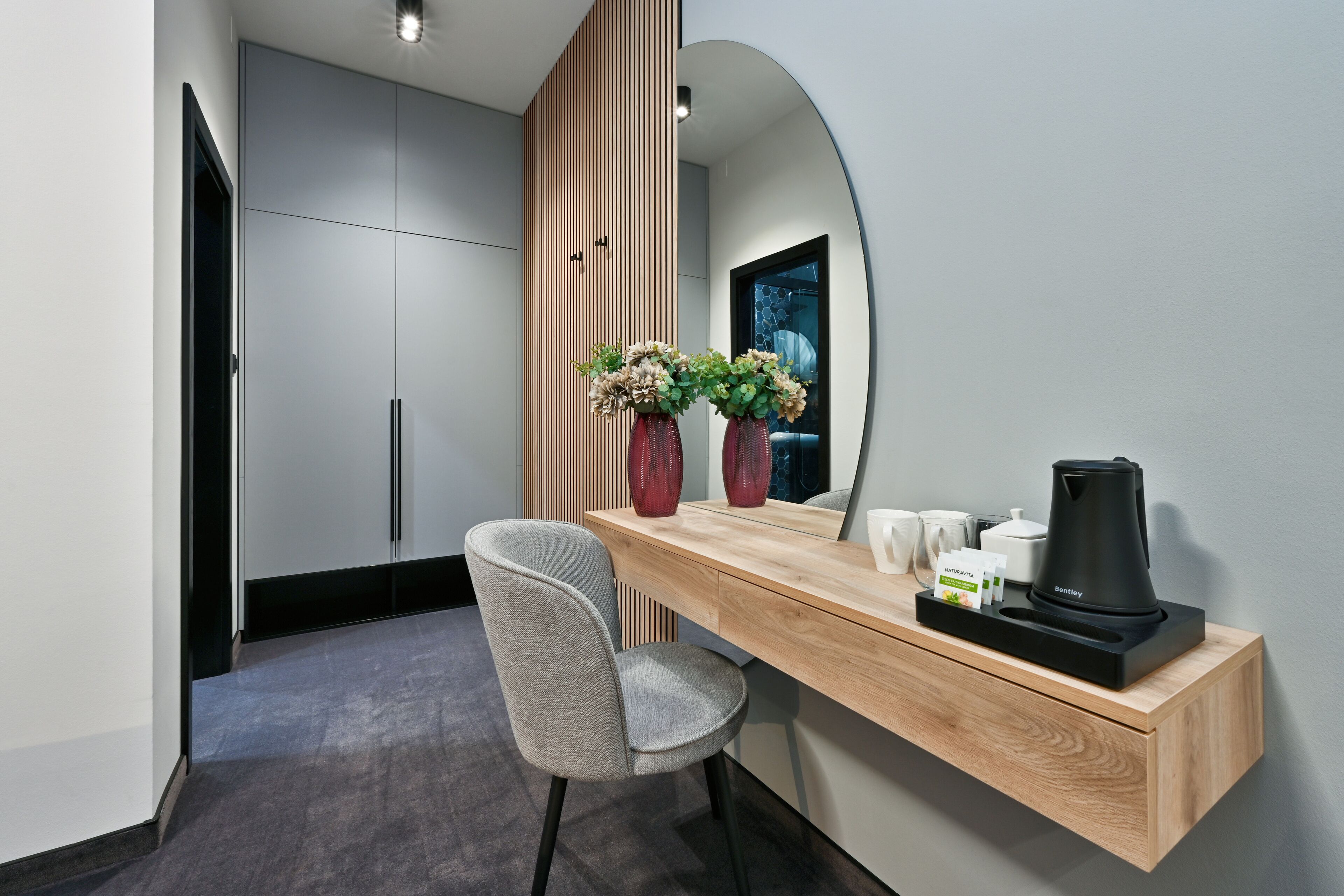 A modern bathroom with a vanity, a mirror, a sink, and a shower area.