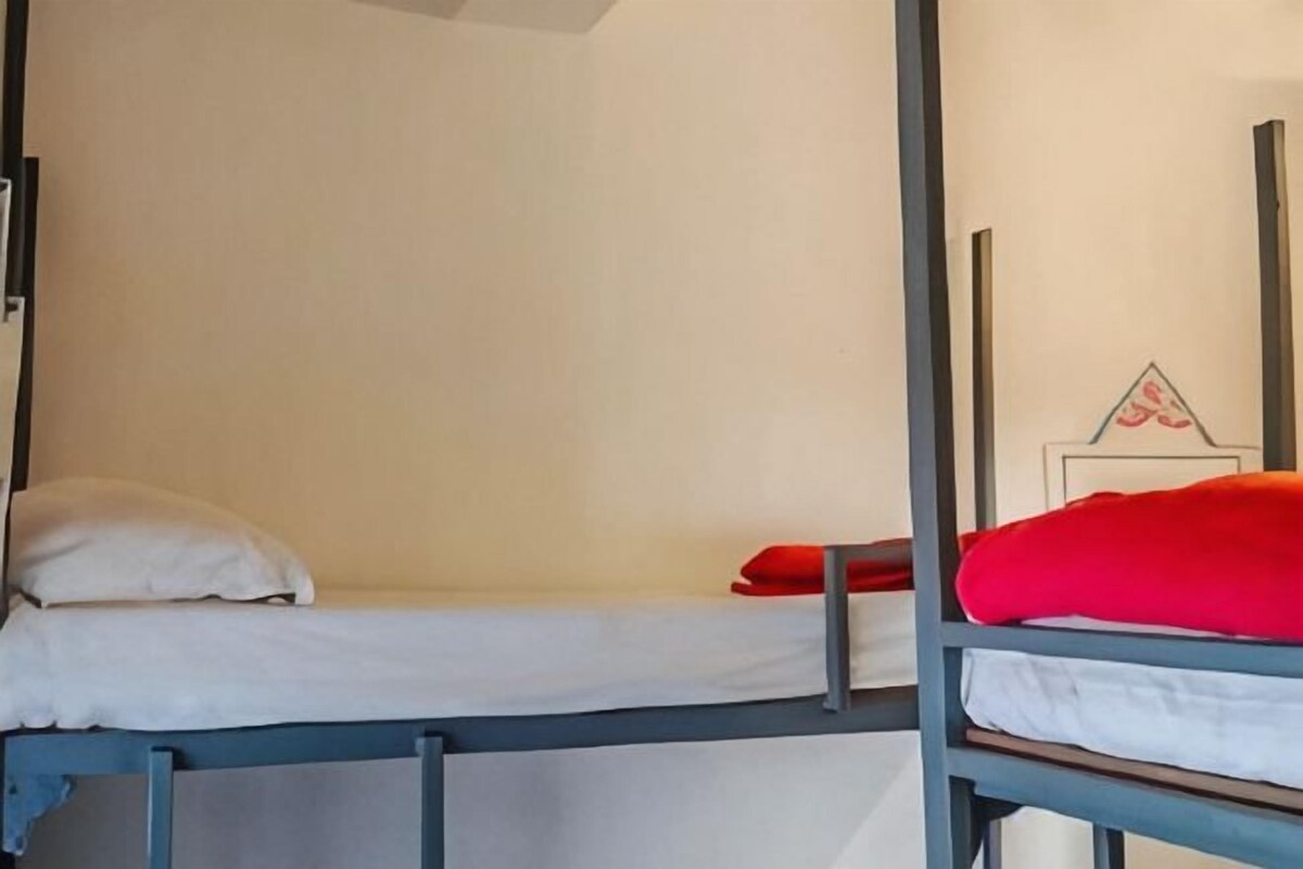 Zwei Stockbetten mit Metallgestellen und weißer Bettwäsche.