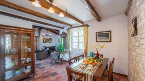 Een eethoek met een houten tafel, stoelen en een buffetkast met glazen deuren.