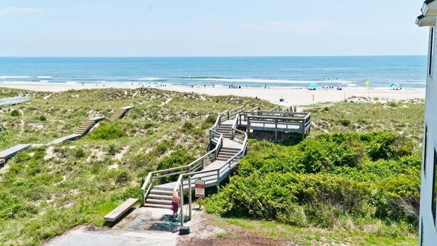 A beach with wooden walkways leading to the shore, a sandy beach, and the ocean in the background. - Point Emerald E-202, Oceanside Condo in Emerald Isle, NC! (Emerald Isle)