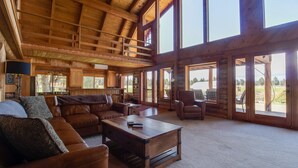 A spacious living room with a high ceiling, large windows, and a cozy seating area. - Private 40-Acre Ranch + Pool, Sauna w/ Yurt (Sisters)