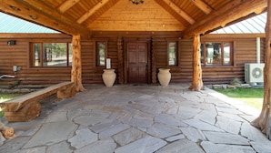 A log cabin with a stone-paved entrance, wooden beams, and a large wooden door. - Private 40-Acre Ranch + Pool, Sauna w/ Yurt (Sisters)