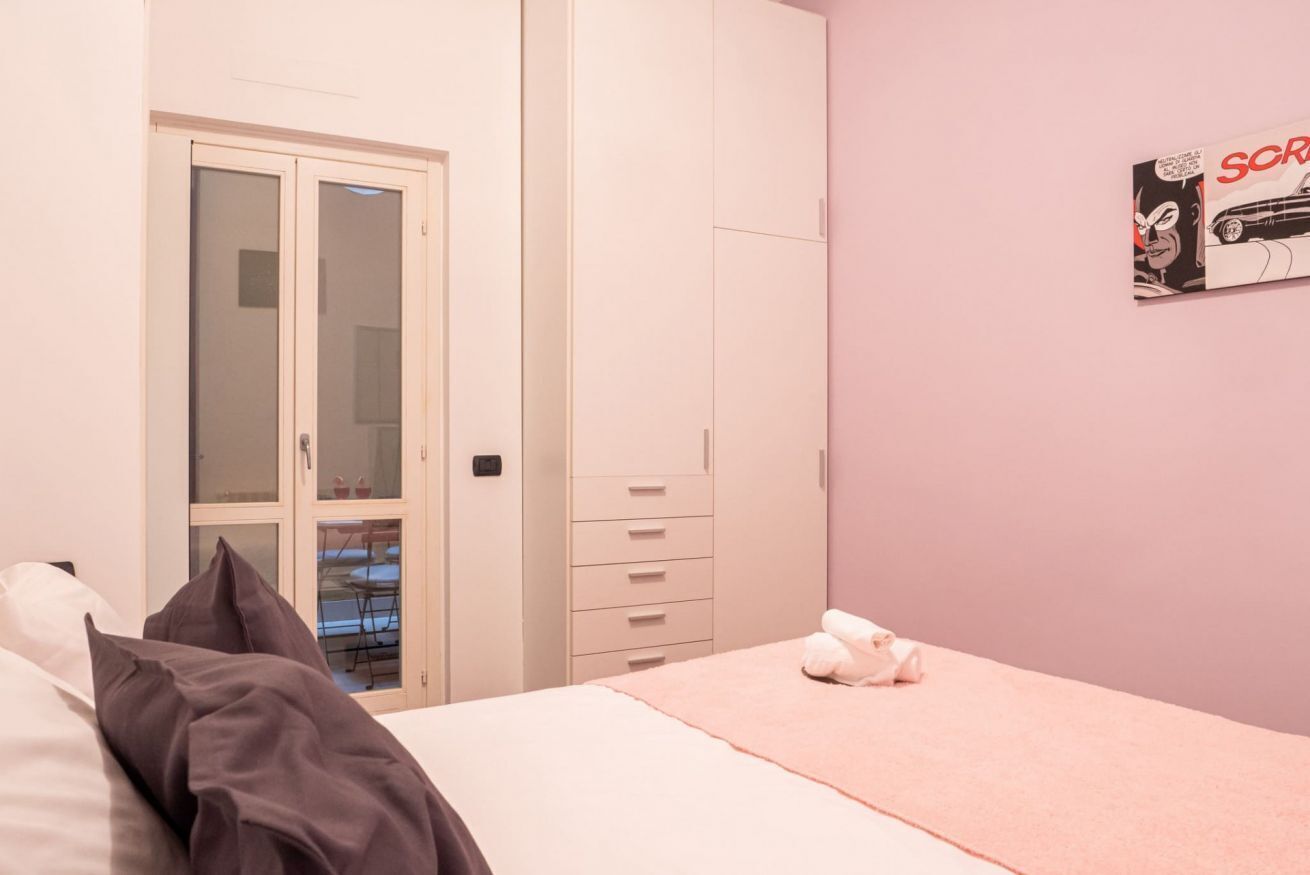 Quarto com cama, guarda-roupa e um quadro na parede.