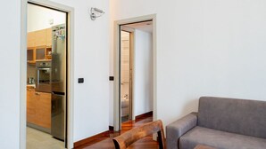 A modern living room with a grey sofa and wooden flooring. - The Best Rent - Two bedroom apartment close to Sondrio metro station (Milano)