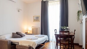 A bedroom with a bed, bedside table, and a window with curtains. - The Best Rent - Two bedroom apartment close to Sondrio metro station (Milano)