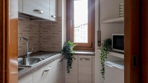 A compact kitchen with a sink, cabinets, and a window. - The Best Rent - Modern two bedroom apartment in the Maciachini area (Milano)