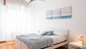 A modern bedroom with a bed, bedside tables, and artwork on the wall. - The Best Rent - Modern two bedroom apartment in the Maciachini area (Milano)