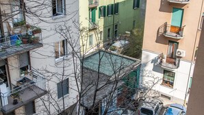 A multi-story residential building with balconies, a visible garage, and a clear view of the street below. - The Best Rent - Apartment in Piazza Cinque Giornate (Milano)