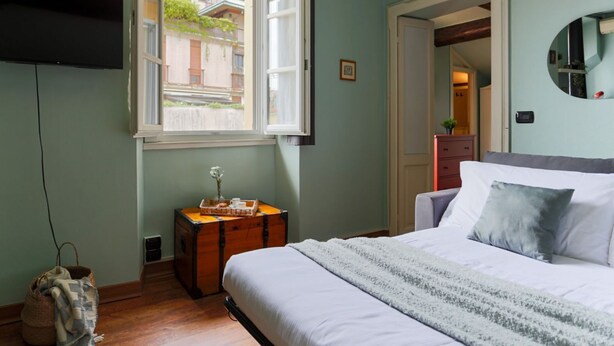 A bedroom with a bed, a dresser, a window, and a mirror. - The Best Rent - Lovely one-bedroom apartment in Brera district (Milano)