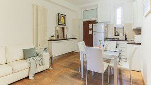 Een knus woongedeelte met een kitchenette, een eethoek en een bank.