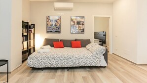 Une chambre à coucher avec un lit, une bibliothèque et deux affiches au mur.