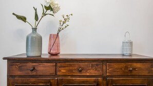A wooden dresser with three vases containing flowers and a lantern. - The Best Rent - Two-bedroom apatment in Milan (Milano)