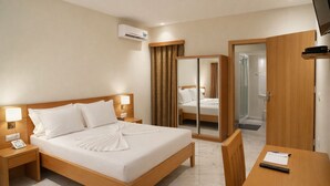 A hotel room with a bed, bedside tables, a desk, a mirror, and an air conditioning unit. - Cruzeiro Guest House (São Filipe)