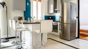 A modern kitchen with a central island, stainless steel appliances, and bar stools.