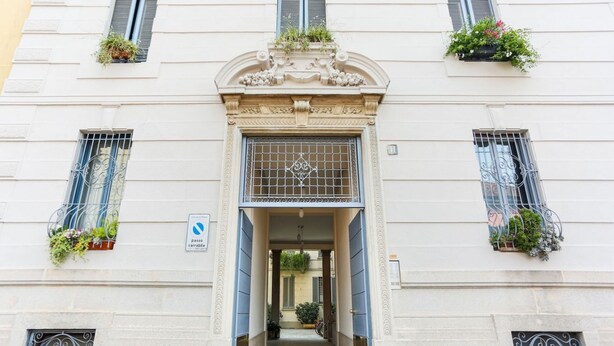 A building entrance with a sign indicating it is accessible. - The Best Rent - Rainbow apartment (Milano)