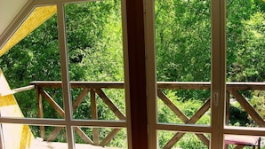 A room with large windows, a wooden deck, and a view of greenery. - Touristic Complex Chychkan (Bala-Chychkan)