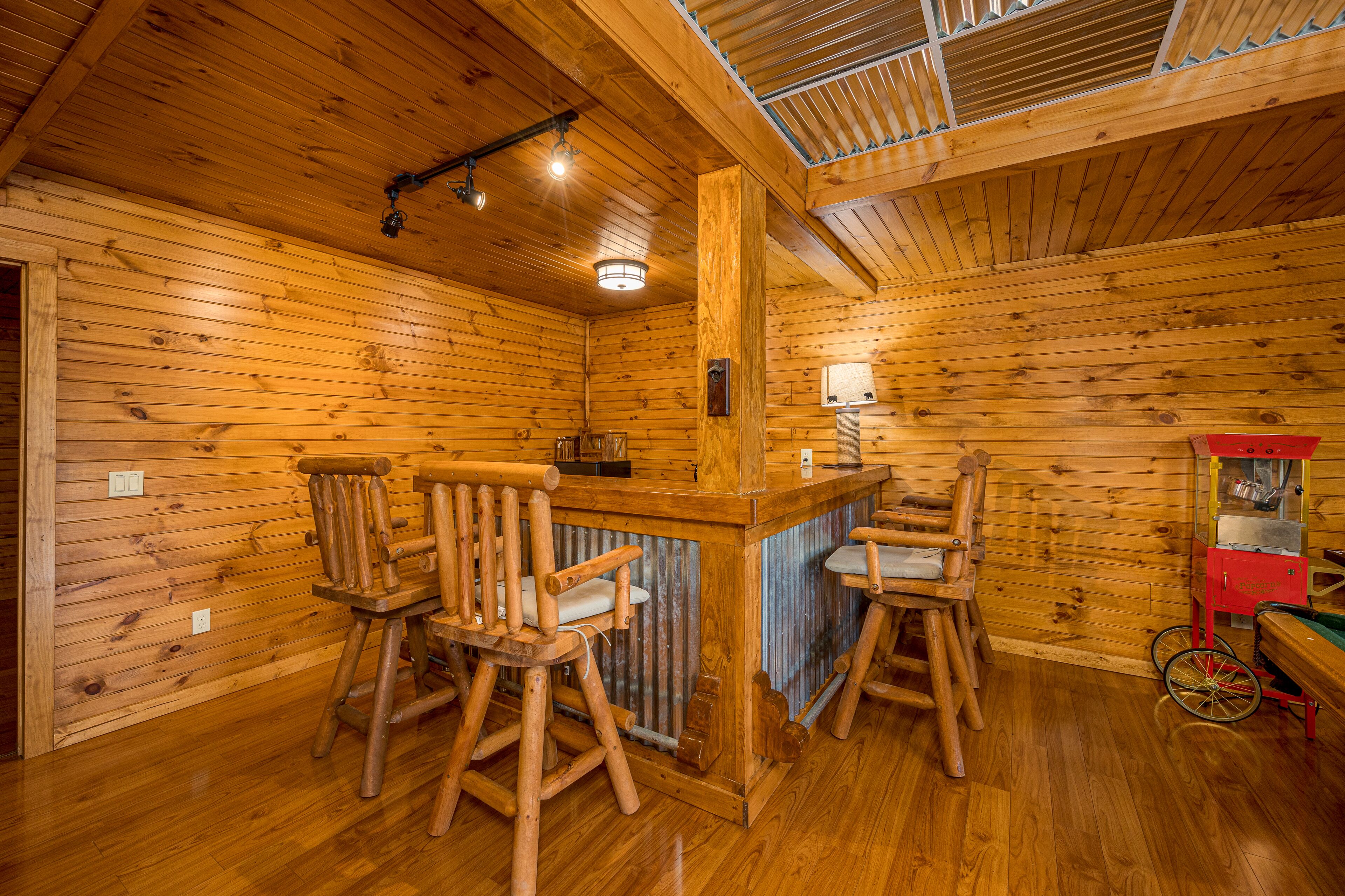 Ein Holzblockhaus im Inneren mit Barbereich, Holzstühlen und einer Vintage-Eismaschine.