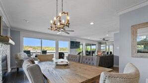 A spacious dining area with a large wooden table, comfortable seating, and a chandelier. - The VIEW @ Farr Shores! (Hot Springs)