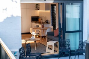 Un appartement moderne comprenant un coin repas, un canapé et une petite table.