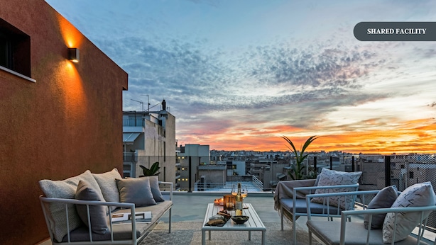 A rooftop terrace with outdoor seating, a table, and decorative lanterns. - Sanders Port - Homely Studio Near Piraeus Port (Piraeus)