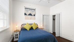 Une chambre à coucher comprenant un lit, deux tables de chevet, une décoration murale et une armoire.