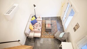 Un salon moderne avec un canapé, une table basse et un tapis à motifs.