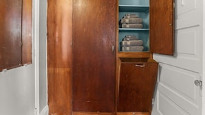 Ein Holzkleiderschrank mit Einlegeböden und einer Schublade, gefüllt mit gefalteten Handtüchern.