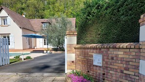 A residential driveway leading to a house with a brick wall and mailbox.