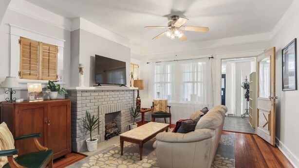 Una sala de estar con chimenea, un sofá, una mesa de centro y un televisor.