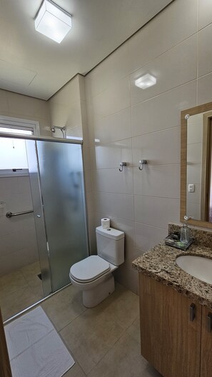 Un baño moderno con ducha, inodoro y lavabo.