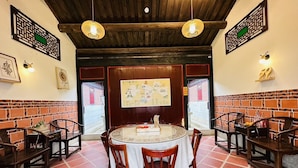 Un comedor con una mesa redonda, sillas y una pizarra con el menú.