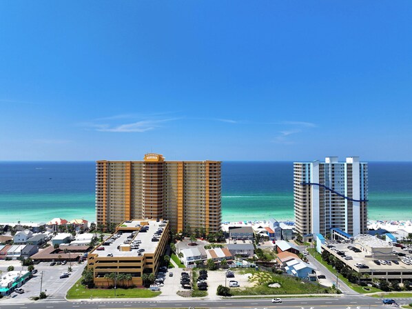 Un paysage urbain côtier avec de hauts immeubles, un parking et une plage.