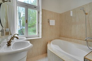 Habitación doble Deluxe | Baño | Tina, toallas, jabón, papel de baño 