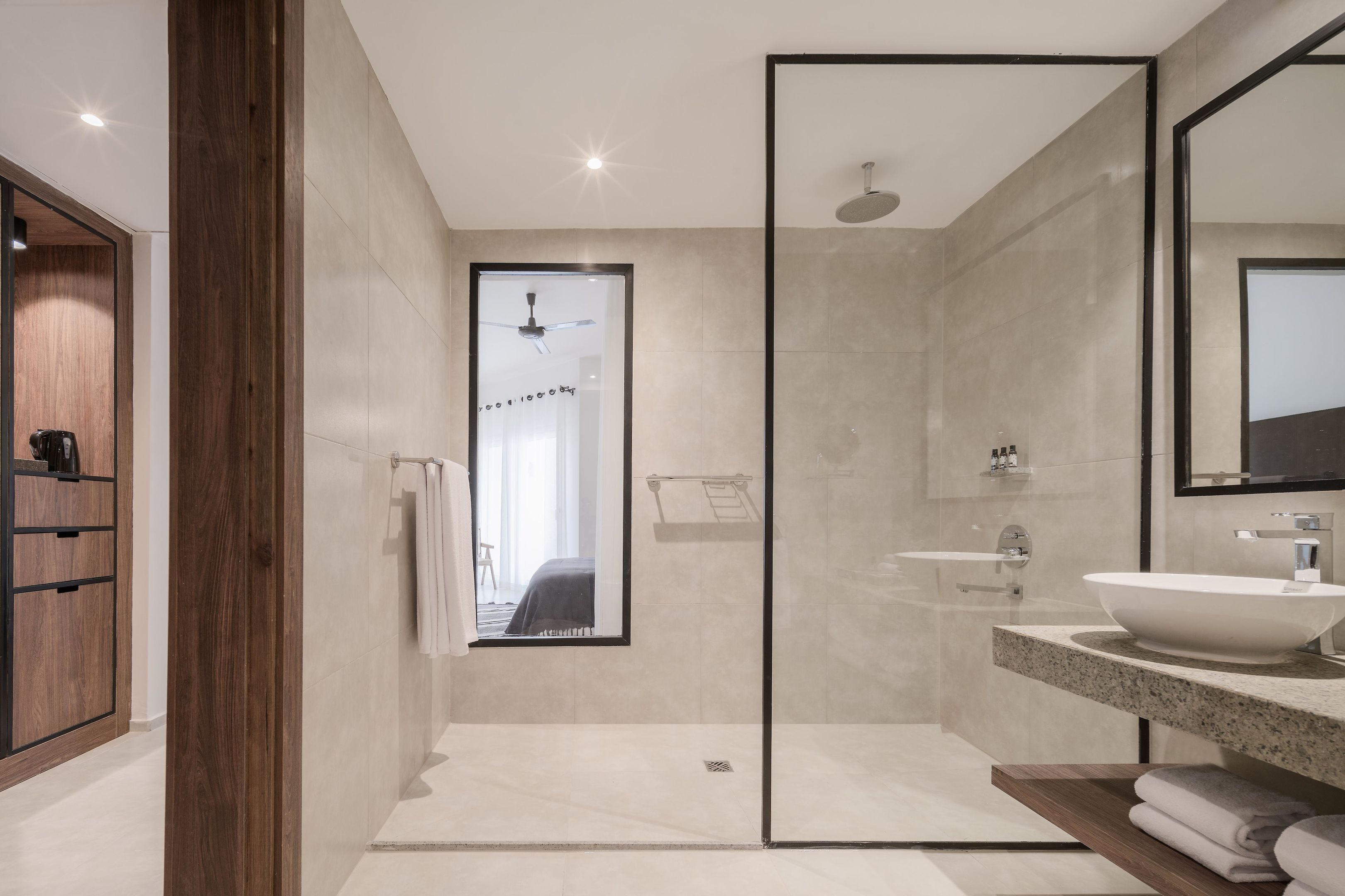 A modern bathroom with a large mirror, a freestanding bathtub, and a shower area.