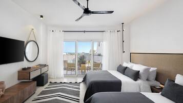 A modern hotel room with two beds, a ceiling fan, a TV, and a balcony with a view.